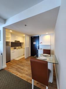 a kitchen with a glass table with a chair at Comfy En-Suite Room in Kota Kinabalu