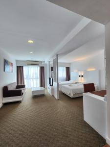 a large hotel room with a bed and a couch at Comfy En-Suite Room in Kota Kinabalu