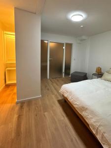a bedroom with a white bed and a wooden floor at Ferienwohnung in Merzig City an der Saar in Merzig