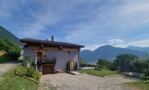 una casa con balcón y montañas al fondo en LE ZÈDÈL - Duplex 100m2 vue montagne, au cœur de la Savoie, au pied des stations de ski, en Aigueblanche