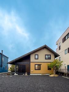 a house in a parking lot next to two buildings at yado suzuka 1 in Suzuka
