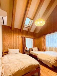 a bedroom with two beds and a chandelier at yado suzuka 1 in Suzuka