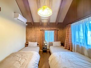 a bedroom with two beds and a chandelier at yado suzuka 1 in Suzuka