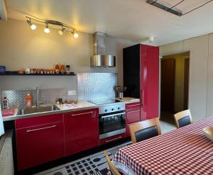 Una cocina con gabinetes rojos y un fregadero. en Apartment with great view at Residence Brunner, en Wengen