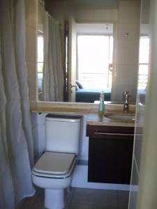 a bathroom with a toilet and a sink and a mirror at Departamento acogedor con excelente ubicación in El Cerrillo
