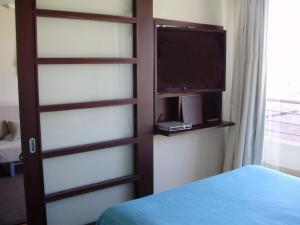 a bedroom with a door with a tv and a bed at Departamento acogedor con excelente ubicación in El Cerrillo