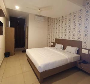 a bedroom with a large bed in a room at Hotel Janani Mansion in Mysore