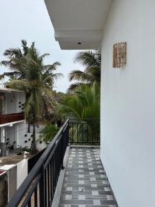 uma vista a partir da varanda de uma casa com palmeiras em Gold Moon Guest House em Weligama