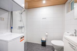 a white bathroom with a toilet and a shower at Auringonsäde Apartments in Kalajoki +18 photos