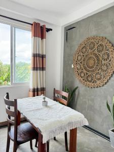 a dining room with a table and chairs and a window at Olaia Apartments and Cafe in Weligama