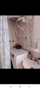 a bathroom with a sink and a toilet and a mirror at Apartman Tamara i Tijana in Škaljari