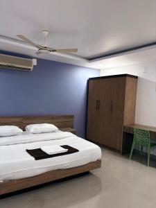 a bedroom with a large bed and a blue wall at Zarica Homestay in Kannur