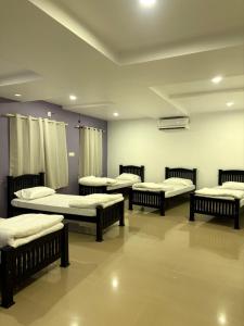 a group of four beds in a room at Zarica Homestay in Kannur +4 photos
