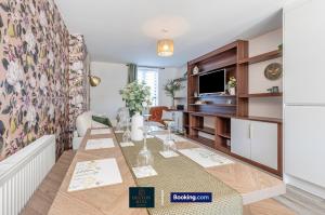 Un comedor con una mesa y un televisor. en Luxury Retreat For 10 - Short Lets & Serviced Accommodation Manchester With Hot Tub and Spacious Garden, en Mánchester 49 fotos más