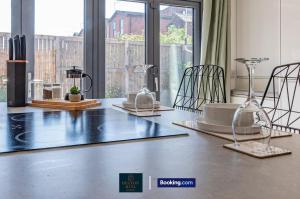 a table with glasses and plates on top of it at Luxury Retreat For 10 - Short Lets & Serviced Accommodation Manchester With Hot Tub and Spacious Garden in Manchester