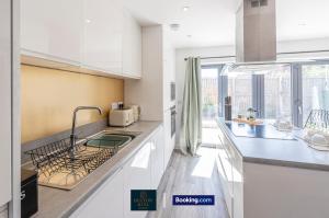 a kitchen with a sink and a counter top at Luxury Retreat For 10 - Short Lets & Serviced Accommodation Manchester With Hot Tub and Spacious Garden in Manchester