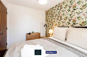 a bedroom with a large bed with a floral wallpaper at Luxury Retreat For 10 - Short Lets & Serviced Accommodation Manchester With Hot Tub and Spacious Garden in Manchester +50 photos