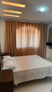 una cama grande en una habitación con ventana en BJLapa Residence 1, en Bom Jesus da Lapa