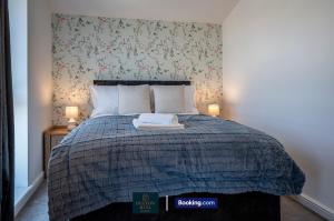 a bedroom with a bed with a blue comforter at Luxury Retreat For 10 - Short Lets & Serviced Accommodation Manchester With Hot Tub and Spacious Garden in Manchester