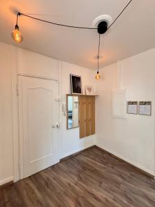 an empty room with white walls and wooden floors at Soh Rent appartement Schiltigheim proche strasbou - 4p - TV - wifi - Balcon in Schiltigheim