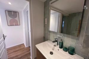 ein Badezimmer mit Waschbecken und Spiegel in der Unterkunft Soh Rent Appartement Schiltigheim proche Strasbourg terrasse -Tv in Schiltigheim + 7 Fotos