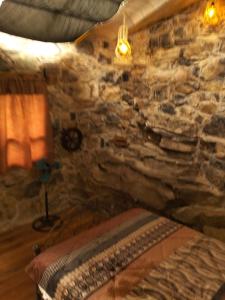a bedroom with a stone wall with a bed in it at Nasaka jacala in Cuetzalán del Progreso +3 photos