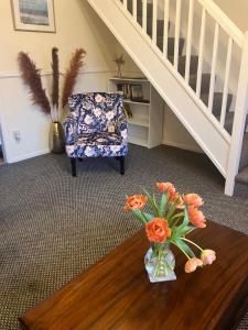 a room with a chair and a vase of flowers on a table at Lavender Cottage in Thirsk