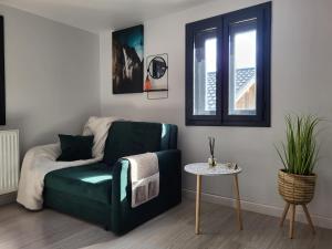 a living room with a green couch and a table at Căsuța Piticilor in Broşteni