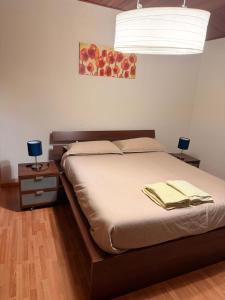 1 dormitorio con 1 cama con 2 mesas y 1 lámpara en respirodabruzzo, en Villetta Barrea