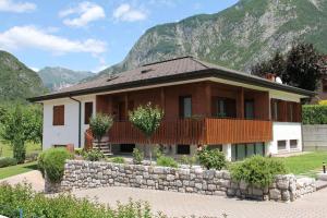 a house with a stone wall in front of a mountain at LA MUELE Affittacamere in Gemona del Friuli