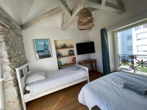a bedroom with a bed and a tv and a window at Maison indépendante cosy avec terrasse privée - La Laiterie in Nantes
