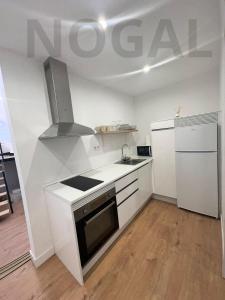una cucina bianca con lavello e fornello di Casa Sergio a Madrid