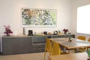 a kitchen with a table and a painting on the wall at LA MUELE Affittacamere in Gemona del Friuli