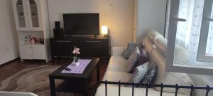 a living room with a white couch and a table at Village Rákoshegy in Budapest