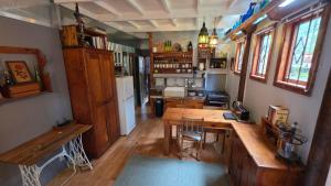 a kitchen with a wooden table in a room at Noordhoek Beach Cabin in Noordhoek