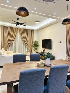 a living room with a table and blue chairs at The Colony Homestay Desaru in Bandar Penawar