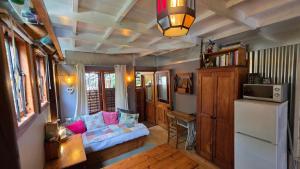 a living room with a couch and a refrigerator at Noordhoek Beach Cabin in Noordhoek