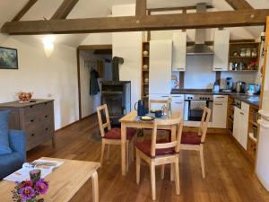 a kitchen and dining room with a table and chairs at Ferienwohnung Koppelblick in Pfarrweisach +14 photos