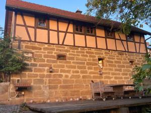 a building with a bench on the side of it at Ferienwohnung Koppelblick in Pfarrweisach