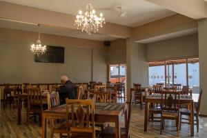 a man sitting at a table in a restaurant at OceanLife Guesthouse and Restaurant Lüderitz in Lüderitz