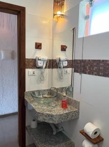 un baño con lavabo y espejo en Estúdio com piscina, en Trancoso