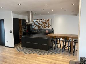 a kitchen with a black island and a wooden table at superbe villa neuve in Aytré