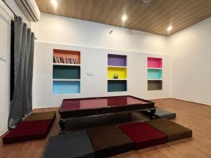 a room with a ping pong table and colorful shelves at Mosaic Hostel Varanasi in Varanasi