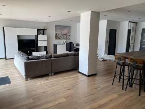 a living room with a couch and a table at superbe villa neuve in Aytré
