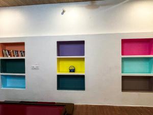 a room with four colorful shelves on a wall at Mosaic Hostel Varanasi in Varanasi