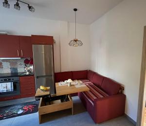 Una sala de estar con un sofá rojo y una mesa. en AA seaside apartment, en Artemida