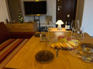 una mesa con una bandeja de plátanos y copas de vino en AA seaside apartment, en Artemida 14 fotos más