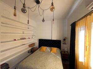 Un dormitorio con una cama y una lámpara de araña. en AA seaside apartment, en Artemida