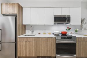 a kitchen with white cabinets and a stove and refrigerator at Elegant Studio Apartment in Steinway +1 photo