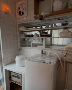a small kitchen with a small white refrigerator at 経堂の小さな一棟貸wakusei in Tokyo